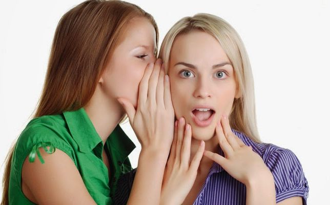 Chica contando algo al oído a otra chica